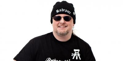 Die Markenzeichen von Markus Krebs sind Ruhrpott-Mütze, die Sonnenbrille – und sein Hocker. Foto: S2 Management 