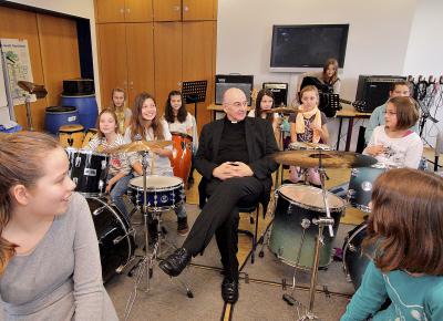 Mitten ins Geschehen setzte sich Bischof Felix Genn bei seinem Besuch in der Percussion-Klasse.