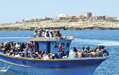 Dr. Elke Kleuren-Schryvers und Pastor Rolf Lohmann stehen neben dem Kreuz, das aus den Planken eines Flüchtlingsbootes in Lampedusa gezimmert wurde. Foto: privat