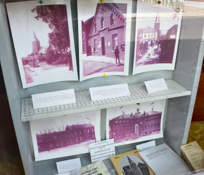 Der Schaukasten mit alten Fotos im Schaufenster der Bäckerei Dams auf der Dorfstraße, von dem sich die Männer vom Haus der Veener Geschichte weitere Erkenntnisse erhoffen.