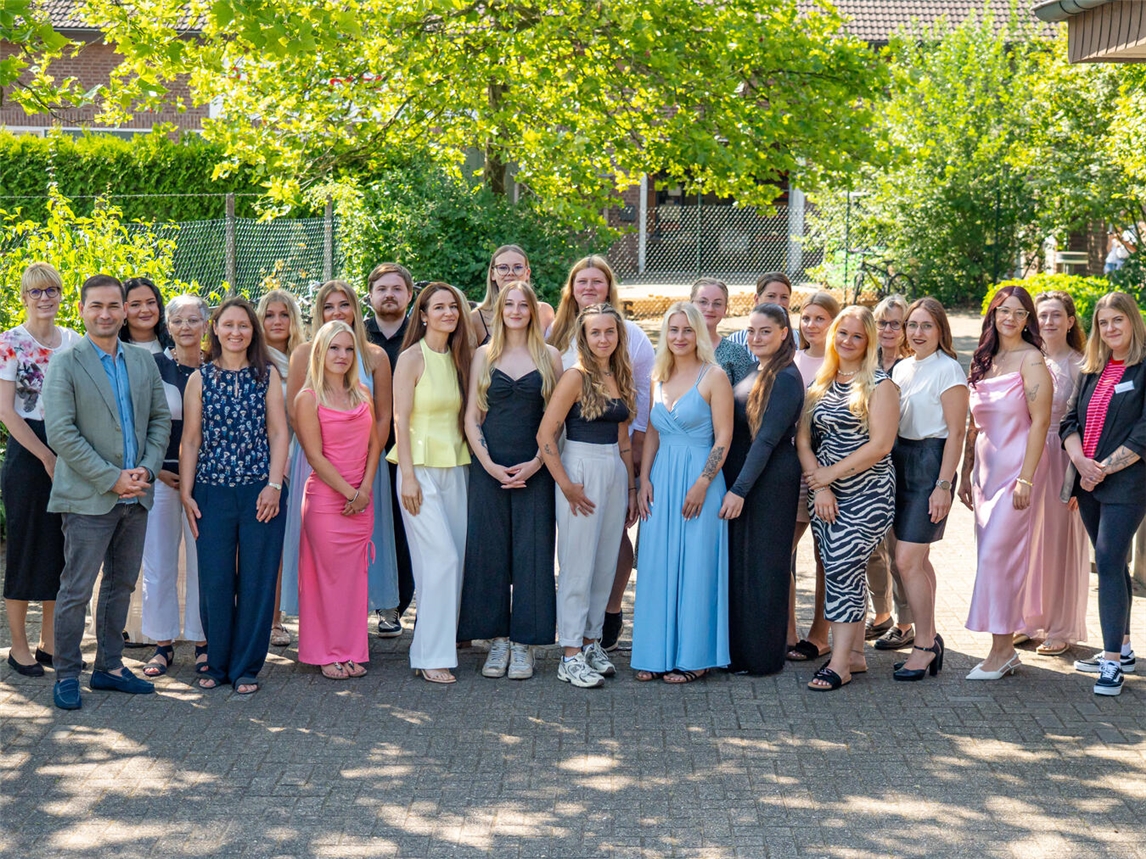 Gruppenfoto von 20 neuen Pflegefachpersonen mit KKLE-Direktorin und Geschäftsführung bei Zeugnisübergabe am 10. Juli.