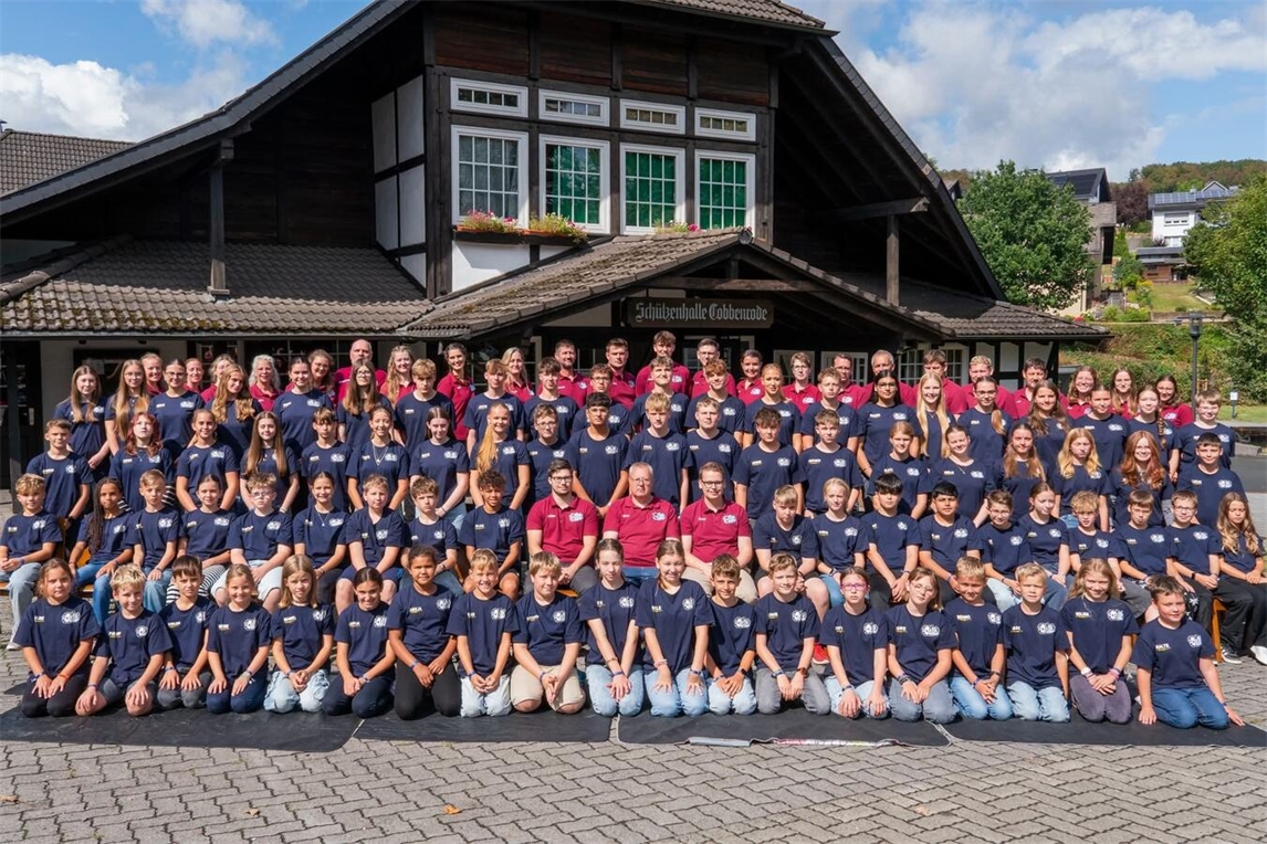 "80 Kinder und Jugendliche genießen Sommerfreizeit im Sauerland, Gruppenbild auf grüner Wiese"