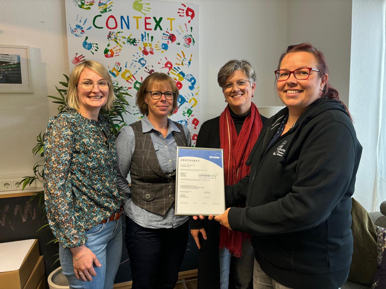 A. Willemsen, M. Look (beide außen, Context e.V.) und I. Garroth, N. Schumann (beide Mitte, TÜV-Nord) freuen sich über das bestandene TÜV-Audit. Foto: Verein Context