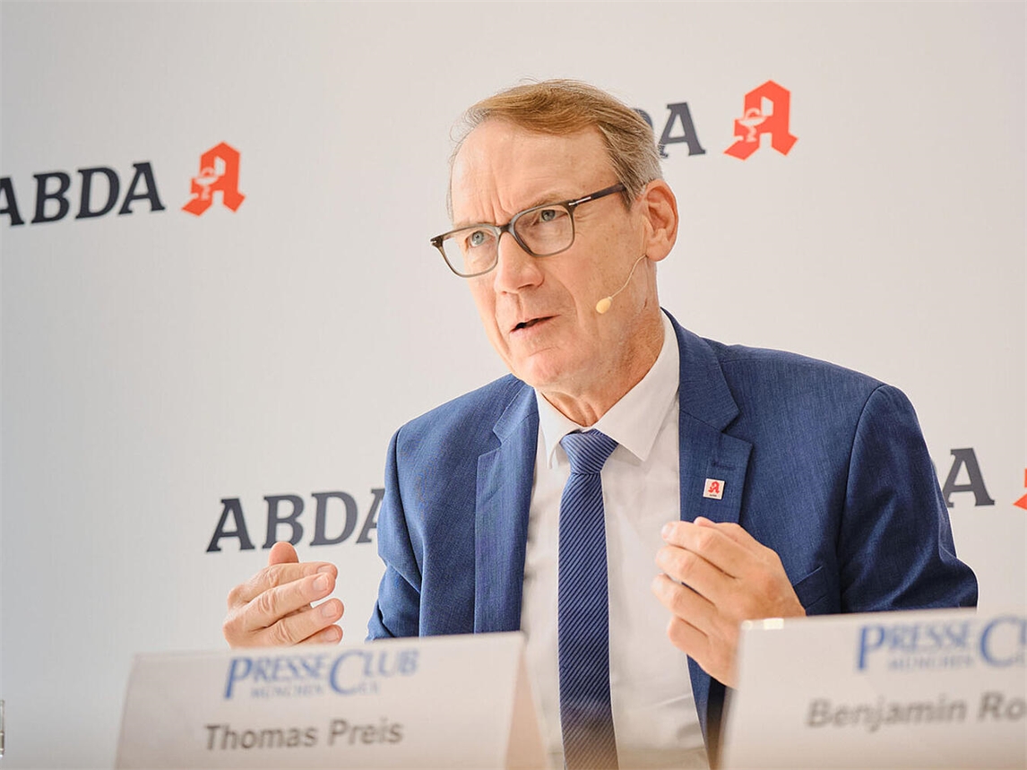 "Porträt von ABDA-Präsident Thomas Preis im Anzug, lächelnd vor neutralem Hintergrund"