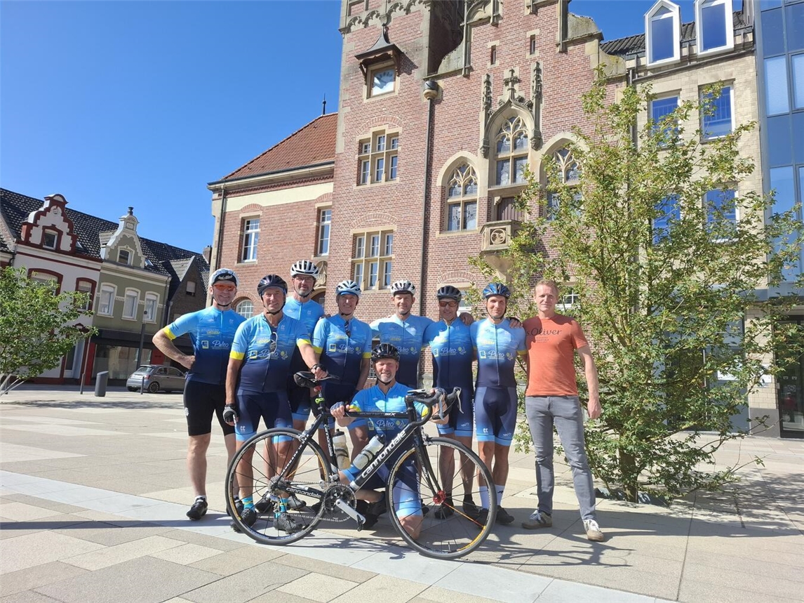 Acht Radfahrer und ein Betreuer auf Landstraße, Radtour, Sport, Teamfahrt, Gruppenreise