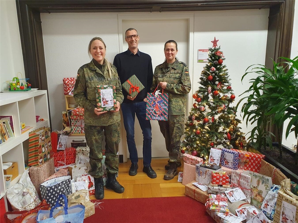 Alexandra Roolfs und Daniela van Hall überreichen Einrichtungsleiter Tobias Neifeind Geschenkespenden. Foto: Caritas