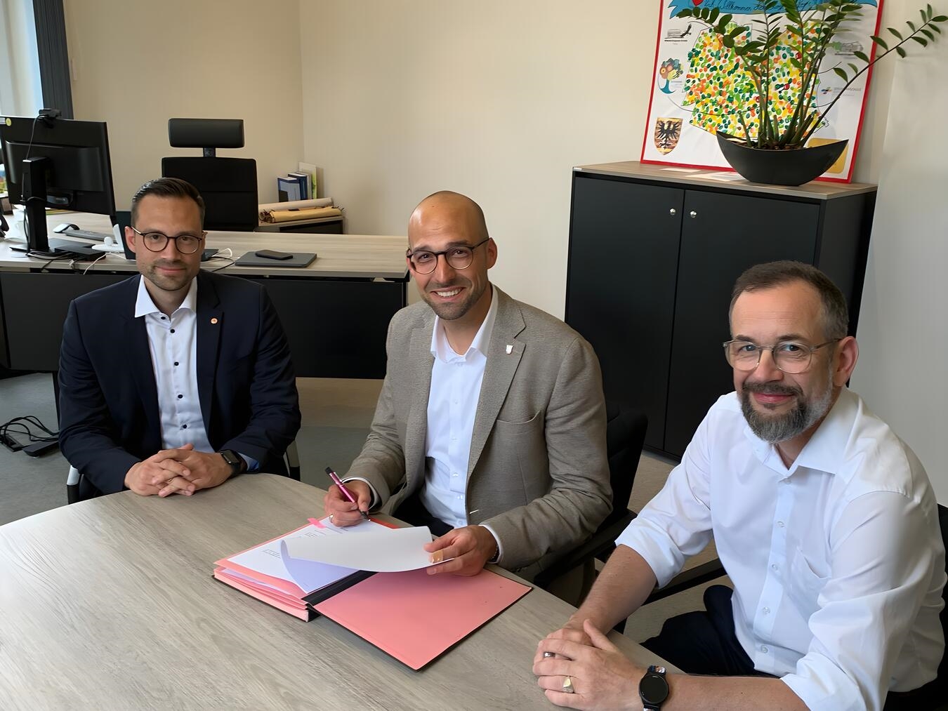 Alpens Bürgermeister Ludger Staymann (m.) sowie die Vertreter der Firma Transdev, Tobias Berger (l.) und Christian Lau (r.), bei der Vertragsunterzeichnung. Foto: Gemeinde Alpen