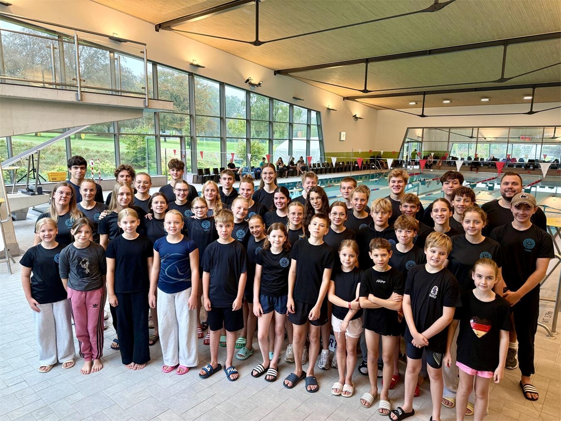 "CSV Kleve Schwimmteam bei Wettkampf, 48 Teilnehmer, Gruppenfoto am Beckenrand"