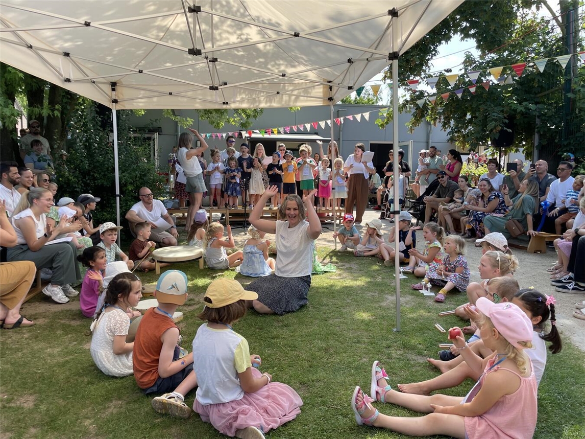 "Fröhliche Feier im Montessori Kinderhaus Kellen am Samstag, Kinder spielen und genießen den Tag."