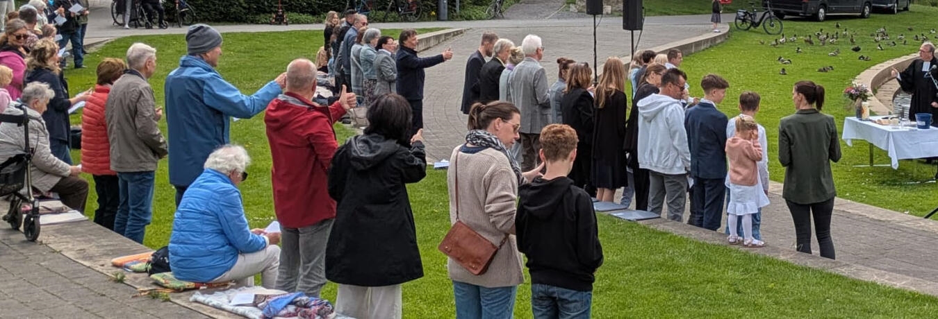 "Gottesdienst an der Nierswelle, Menschen feiern im Freien, spirituelle Zusammenkunft, Gemeinschaft, Natur"