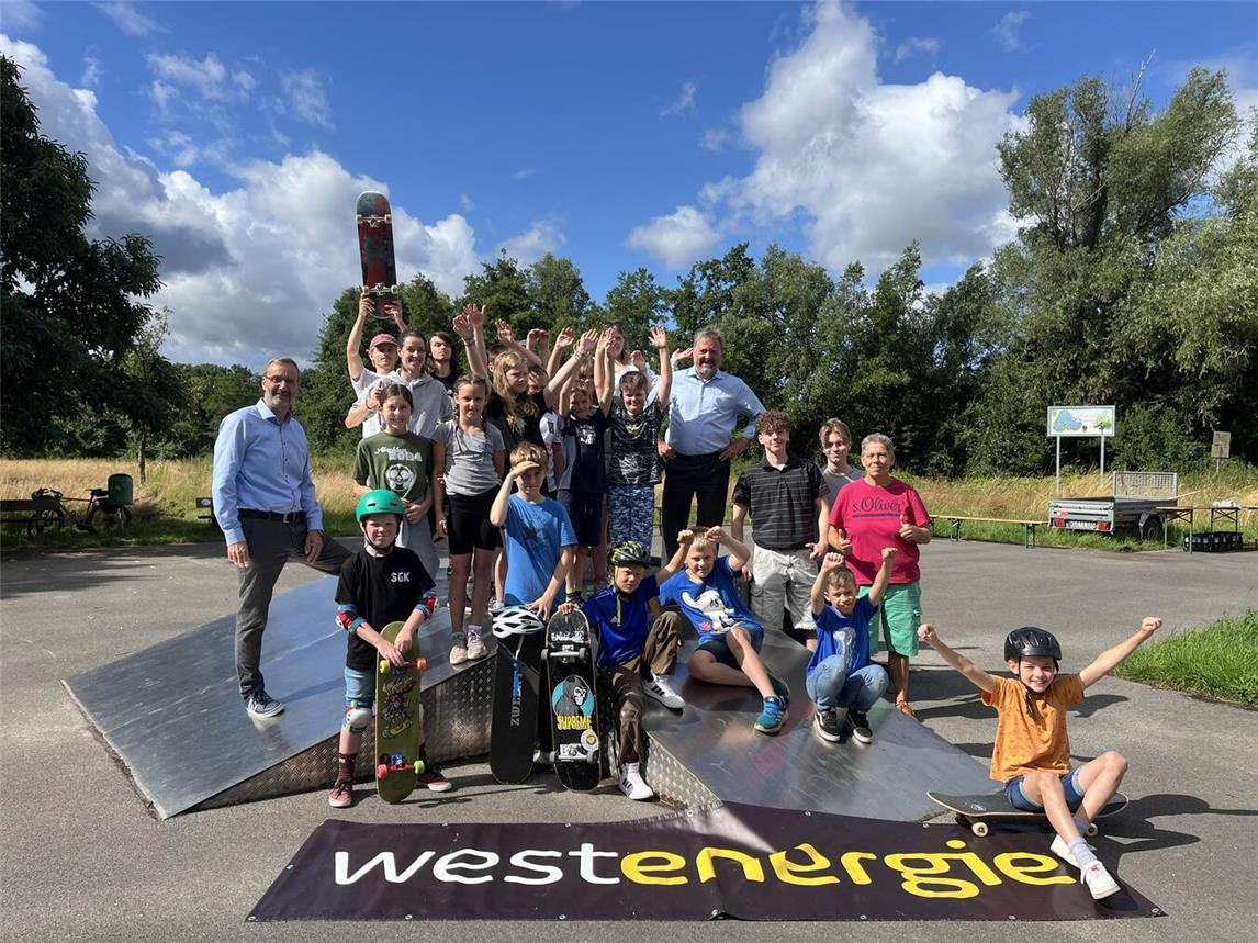 An zwei Tagen lernen die Kinder und Jugendlichen in Issum das Rüstzeug zum sicheren Fahren auf vier Rollen. Bürgermeister Clemens Brüx (hinten 4. v. r.) und Frithjof Gerstner, Westenergie-Kommunalmanager (l.) begrüßten die Teilnehmer am Anfang des Workshops.Foto: Westenergie AG