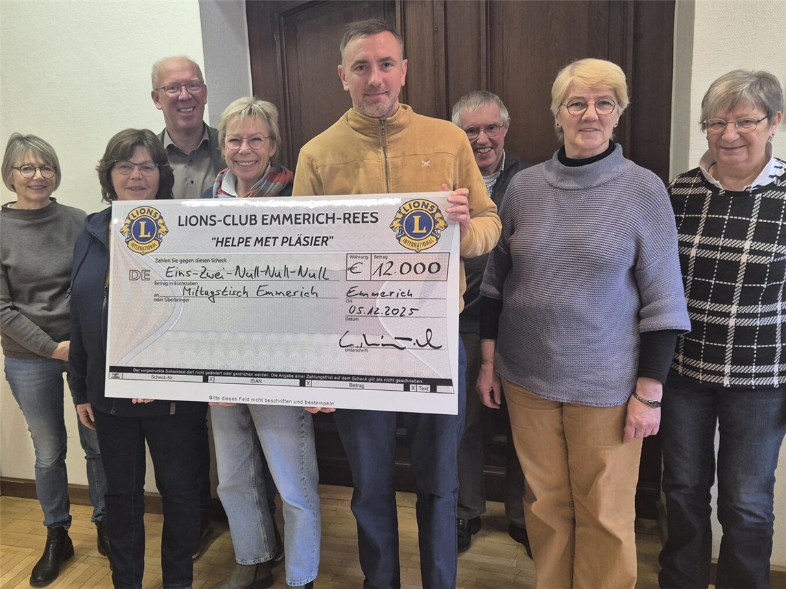 Andrea Schaffeld (4. v. l.) vom Emmerich Mittagstisch mit Lionspräsident Lutz Reinhart-van Gülpen (4. v. r.) bei der symbolischen Scheckübergabe. Foto: privat