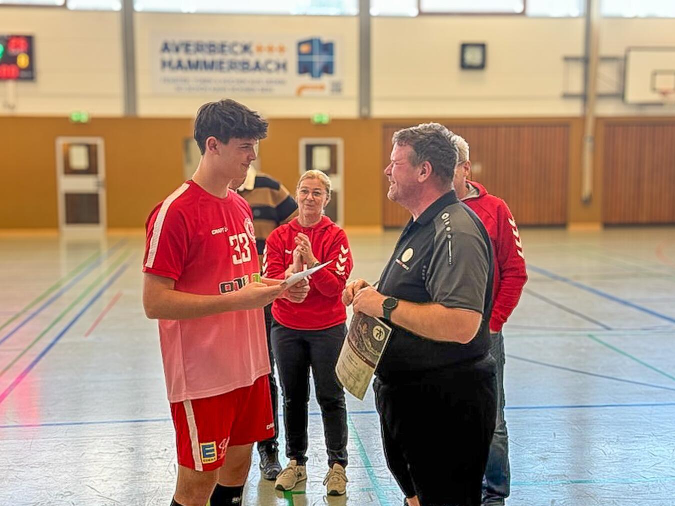 Andreas Zimmermann (Handballkreis Wesel) (r.) überreichte unter anderem Fabio Kloep (l.) im Beisein von Elke Terlinden (M.) die Meister-Urkunde.