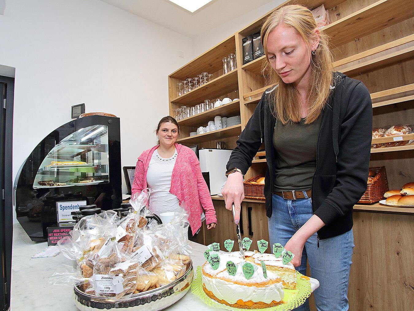 „Inselbrot Wardt“ feiert endlich Eröffnung Anike Steinkuhl schneidet den ersten „Inselbrot-Laden“-Kuchen an.NN-Fotos (3): Theo Leie