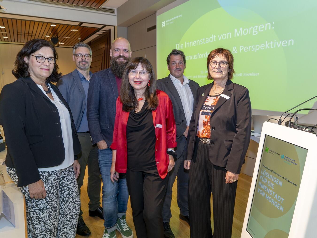 Annegret Welbers (Musikhaus Welbers), Marc Cattelaens (Wirtschaftsförderung Kreis Kleve), Jens Nußbaum (Stadt + Handel Beckmann und Föhrer Stadtplaner GmbH) Susanne Rexing (Einrichtungshaus Rexing), Richard Thielen (Geschäftsführer Handelsverband Nordrhein-Westfalen – Kreis Kleve) und Brigitte Jansen (Geschäftsführerin Wirtschaftsförderung Kreis Kleve, v.l.n.r.) bei der Veranstaltung im Konzert- und Bühnenhaus Kevelaer.Foto: WfG Kreis Kleve