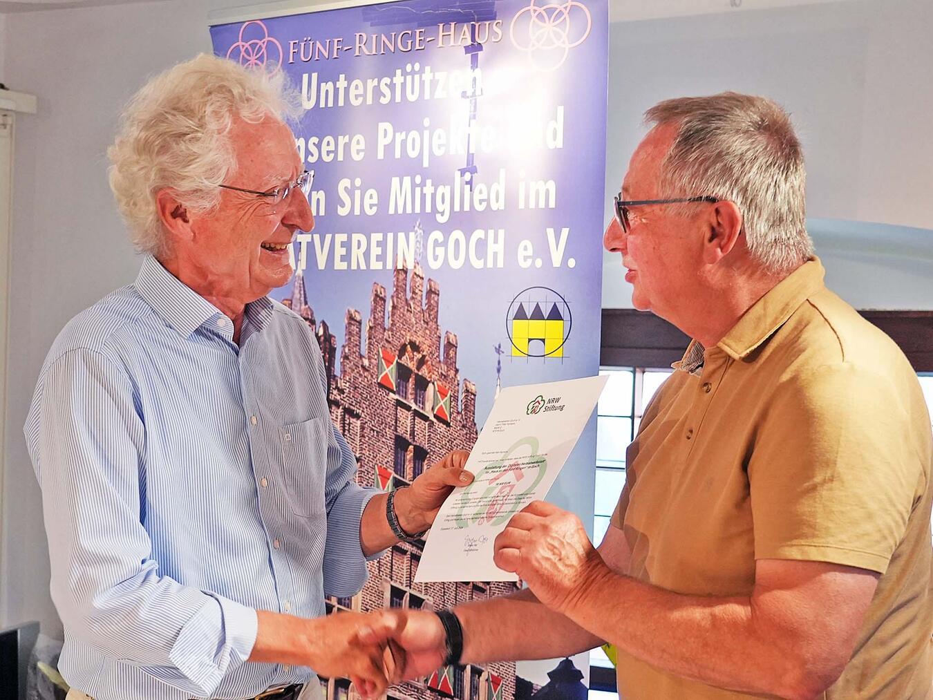 Armin Huber übergibt die Förderurkunde der NRW-Stiftung.