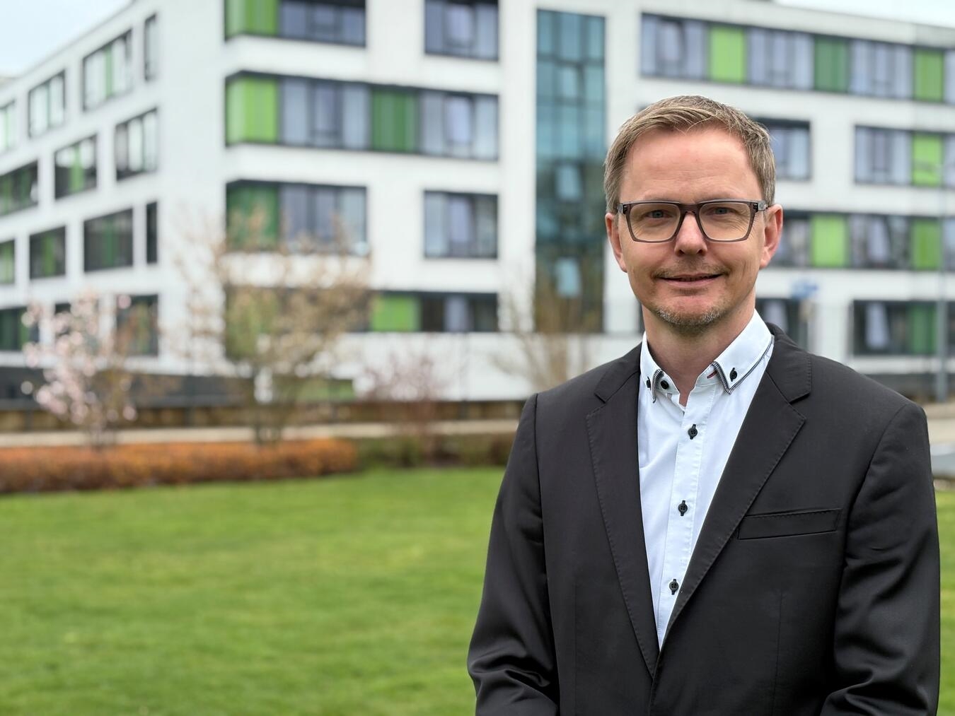 "Arnold Krenz, neuer Hospital Manager bei KKLE, lächelnd im Büro, Management, Gesundheitswesen"