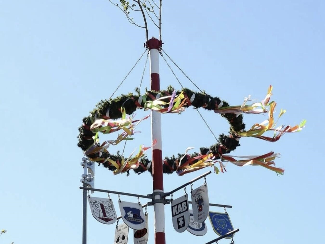 "Besucher genießen Maibaumfeier 2023 in Hau bei sonnigem Wetter, traditionelles Fest"