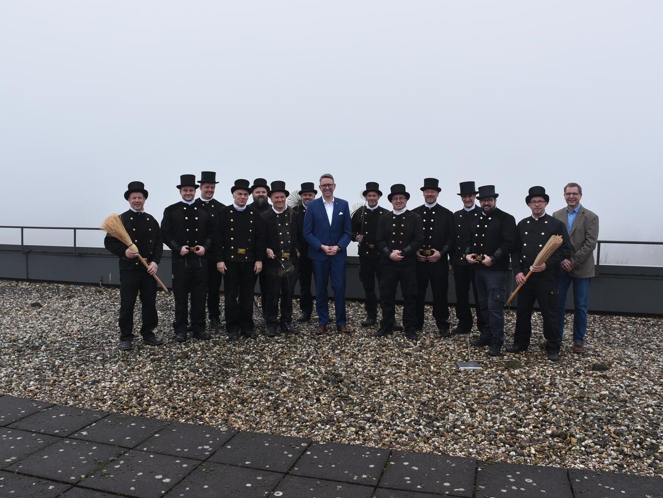 Auf dem Dach des Kreishauses: Landrat Ingo Brohl, Vorstand für Sicherheit und Ordnung Dr. Lars Rentmeister und die Schornsteinfeger beim traditionellen Neujahrsbesuch. Foto: Kreis Wesel