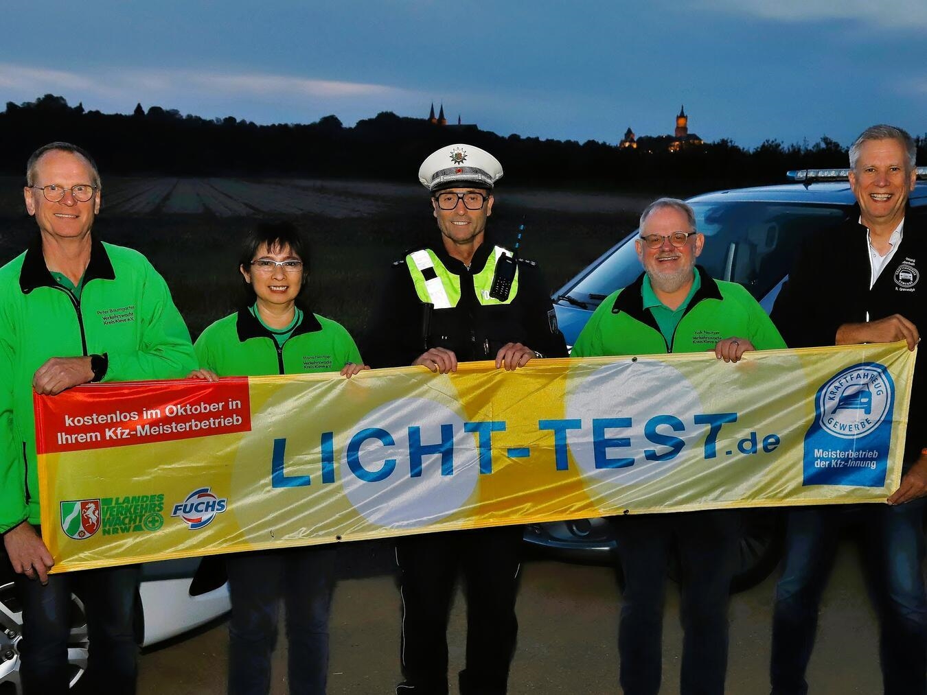 Auf dem diesjährigen Foto setzen neben Peter Baumgarten, Thomas Hermes und René Gravendyk auch Falk Neutzer, Geschäftsführer der Verkehrswacht Kreis Kleve, und Vorstandsmitglied Mona Neutzer ein sichtbares Zeichen für die Aktion. Vor der abendlichen Silhouette Kleves mit der beleuchteten Schwanenburg passt die Aufnahme zum Beginn der dunklen Jahreszeit. Die gemeinsame Botschaft lautet: Licht prüfen lassen, sichtbar bleiben und sicher durch Herbst und Winter kommen. Foto: Falk