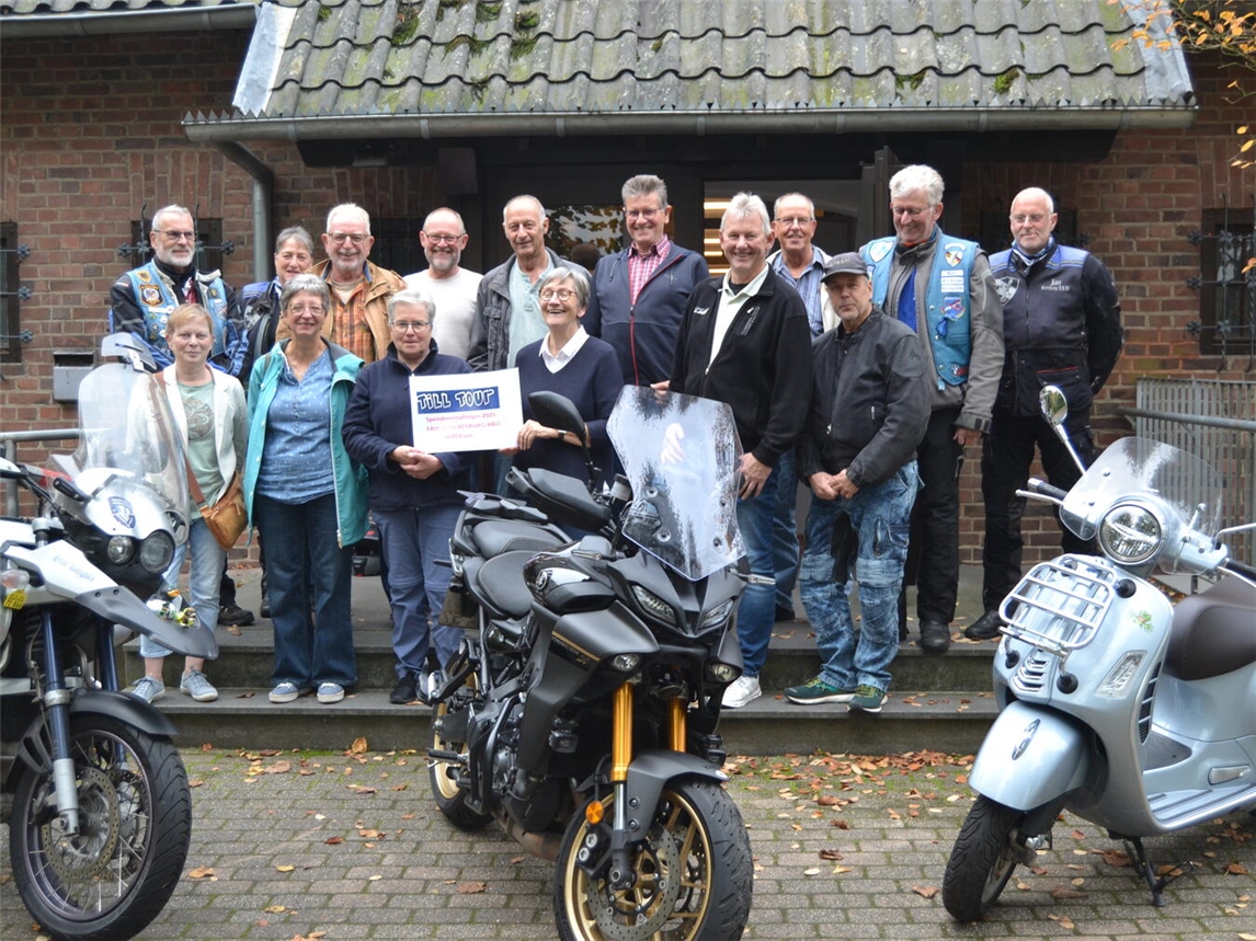 Auf dem Foto nimmt Margret Schild (vorne, 4.v.l.) vom Fair-teiler den symbolischen Spendenscheck entgegen. Foto: Klaus Schwering