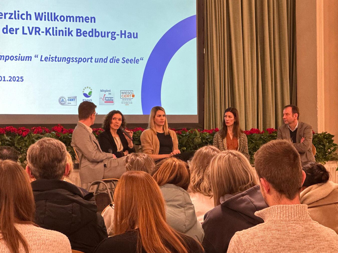 Auf dem Podium: Dr. Nikolaus Barth, Chefarzt Kinder- und Jugendpsychiatrie, im Gespräch mit Anna Esser, Psychologin und Balletttänzerin, Sonja Greinacher, Olympiasiegerin im 3x3 Basketball und Psychologin, Dr. med Gertraud Gradl-Dietsch, Oberärztin LVR-Klinik Essen, und Frederik Koenen, Leiter Bildungszentrum und Pflegeschule. Foto: LVR-Klinik Bedburg-Hau