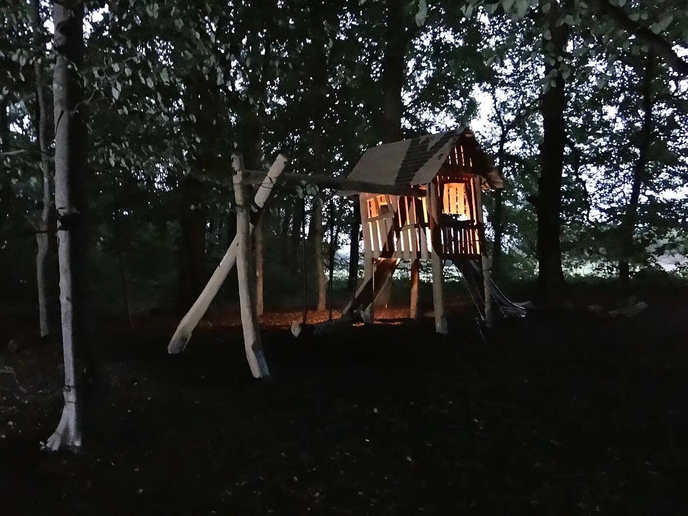 Der Waldspielplatz in Elten, beleuchtete Spielgeräte und dunkle Bäume, Foto von WfG Emmerich.