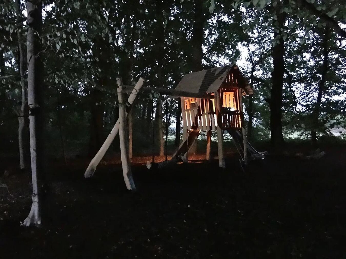 Der Waldspielplatz in Elten, beleuchtete Spielgeräte und dunkle Bäume, Foto von WfG Emmerich.