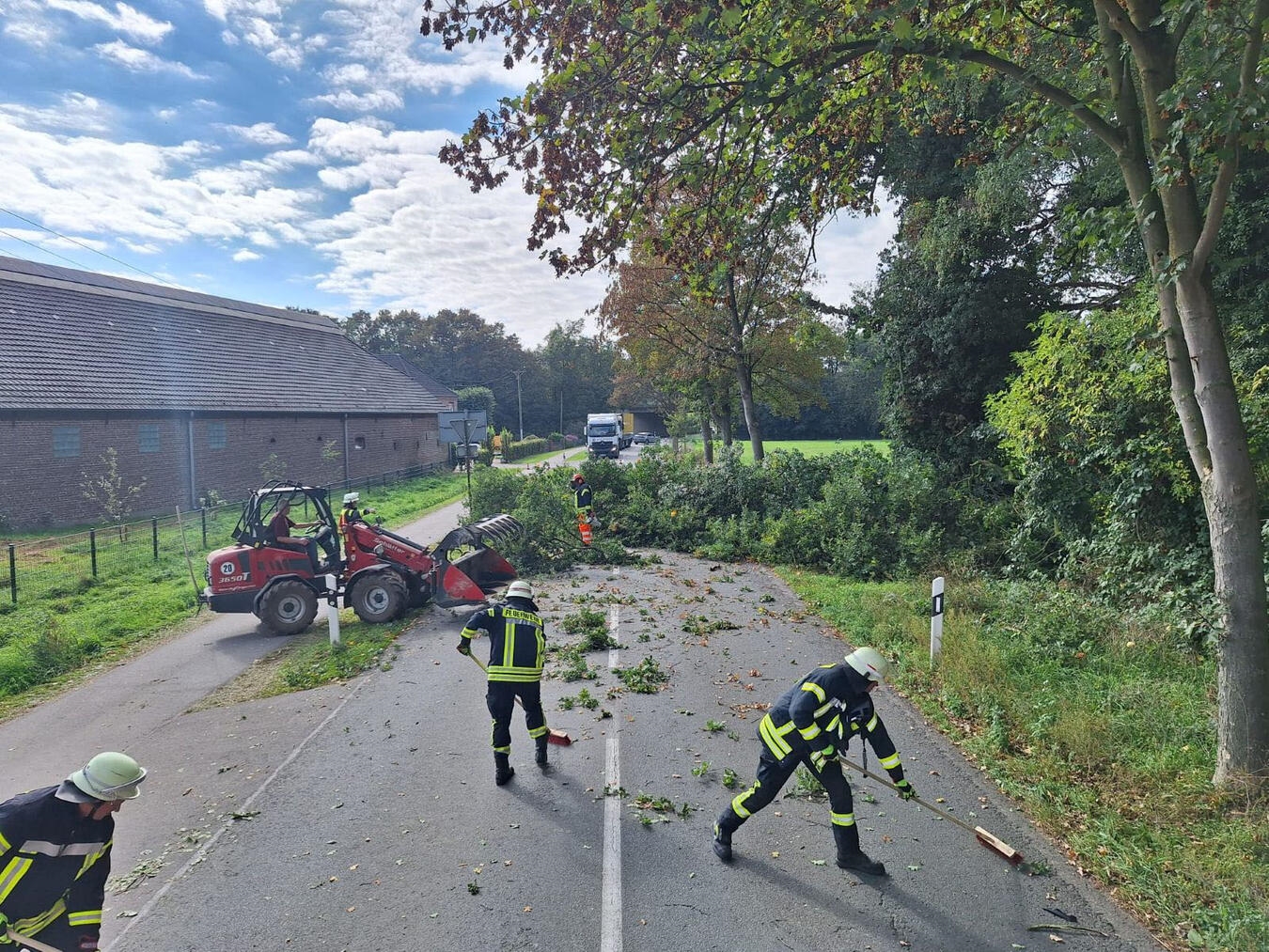 Großer Baumast blockiert Haagsche Straße, beschädigter PKW nach Kollision, Feuerwehr Sonsbeck im Einsatz.
