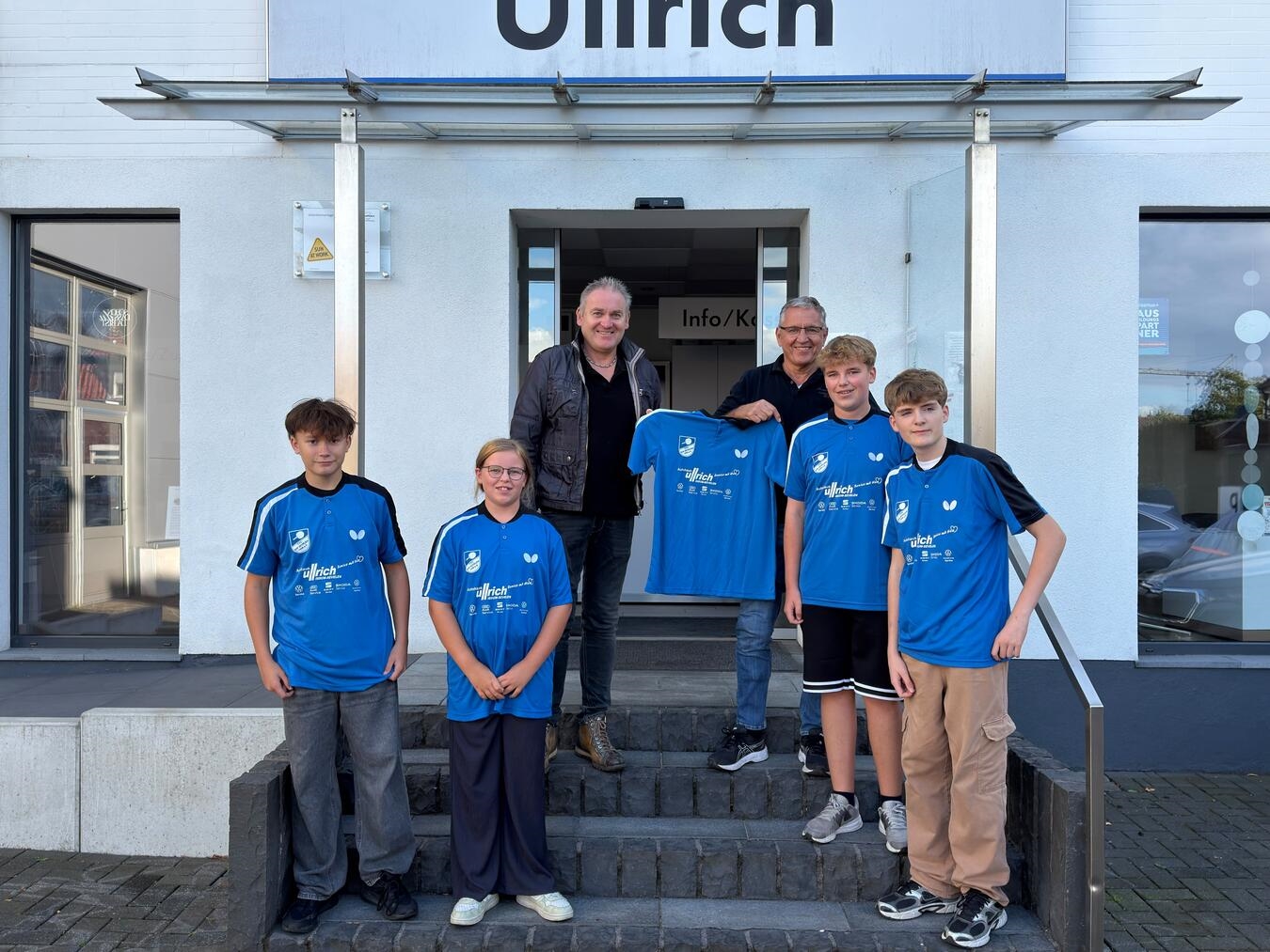 Autohaus-Inhaber Peter Ullrich (oben l.) hat die Trikots dem 1. Vorsitzenden Bernd Loeven (r.) sowie einigen Kindern und Jugendlichen der Jugendabteilung symbolisch übergeben. Foto: privat