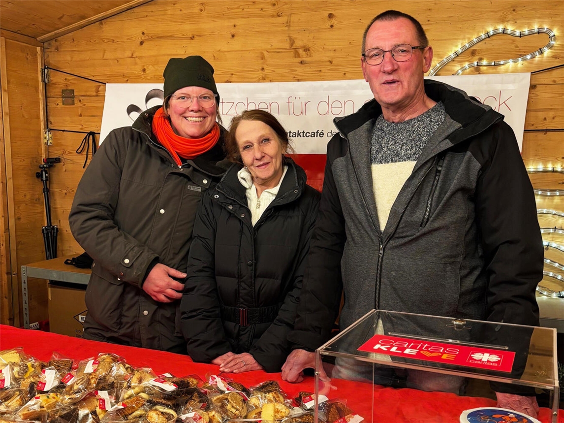 Barbara Kortland (v.l.), Gerda Holdermann und Manfred Stoffelen in der Vereinsbude auf dem Klever Weihnachtsmarkt. Mit dem Plätzchenverkauf hat der Caritasverband Kleve insgesamt 1000 Euro fürs Kontaktcafé eingenommen. Foto: Caritas Kleve