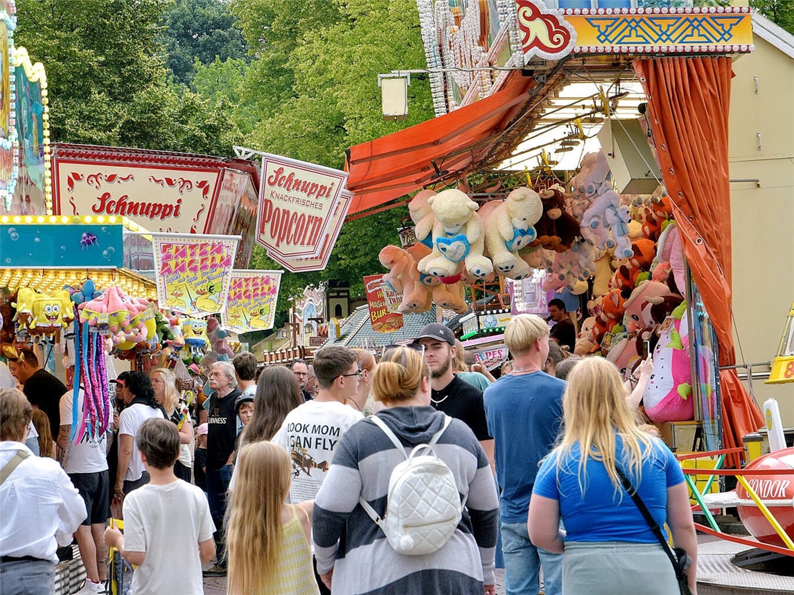 "Menschenmenge bei der Materborner Kirmes mit bunten Fahrgeschäften im Hintergrund, Foto von Rüdiger Dehnen"