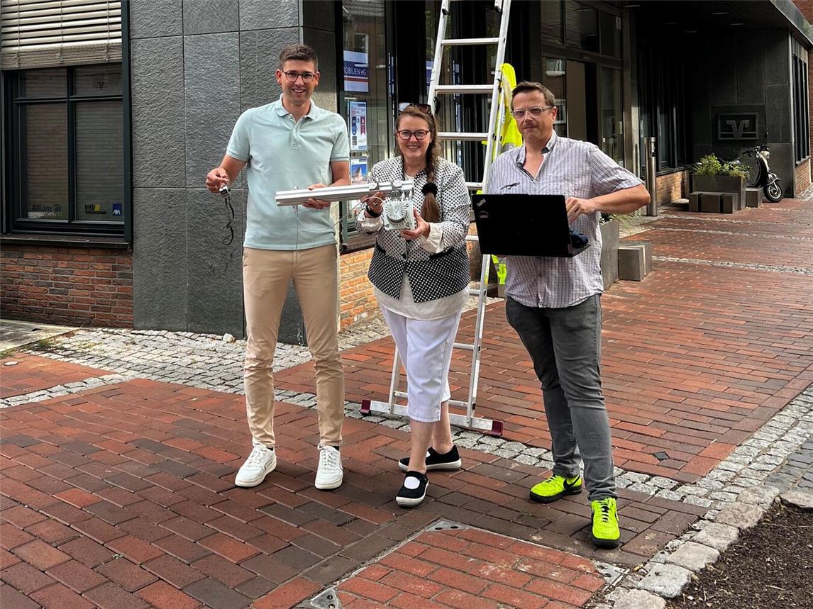 Bei der Montierung des Laserscanners: (v. l.) Jörn Franken, Stabsstellenleitung Öffentlichkeitsarbeit, Stadtmarketing, Tourismus und Kultur Stadt Rees, mit Wirtschaftsförderin Sandra Kimm-Hamacher und einem technischen Mitarbeiter der Firma Lase Industrielle Lasermesstechnik. Foto: Stadt Rees