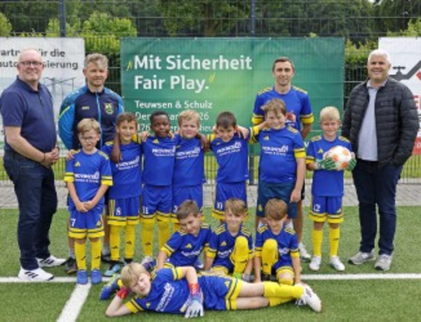 "Ralf Teuwsen und Nicolas Schulz überreichen neue Trikots an Nachwuchskicker bei feierlicher Übergabe"