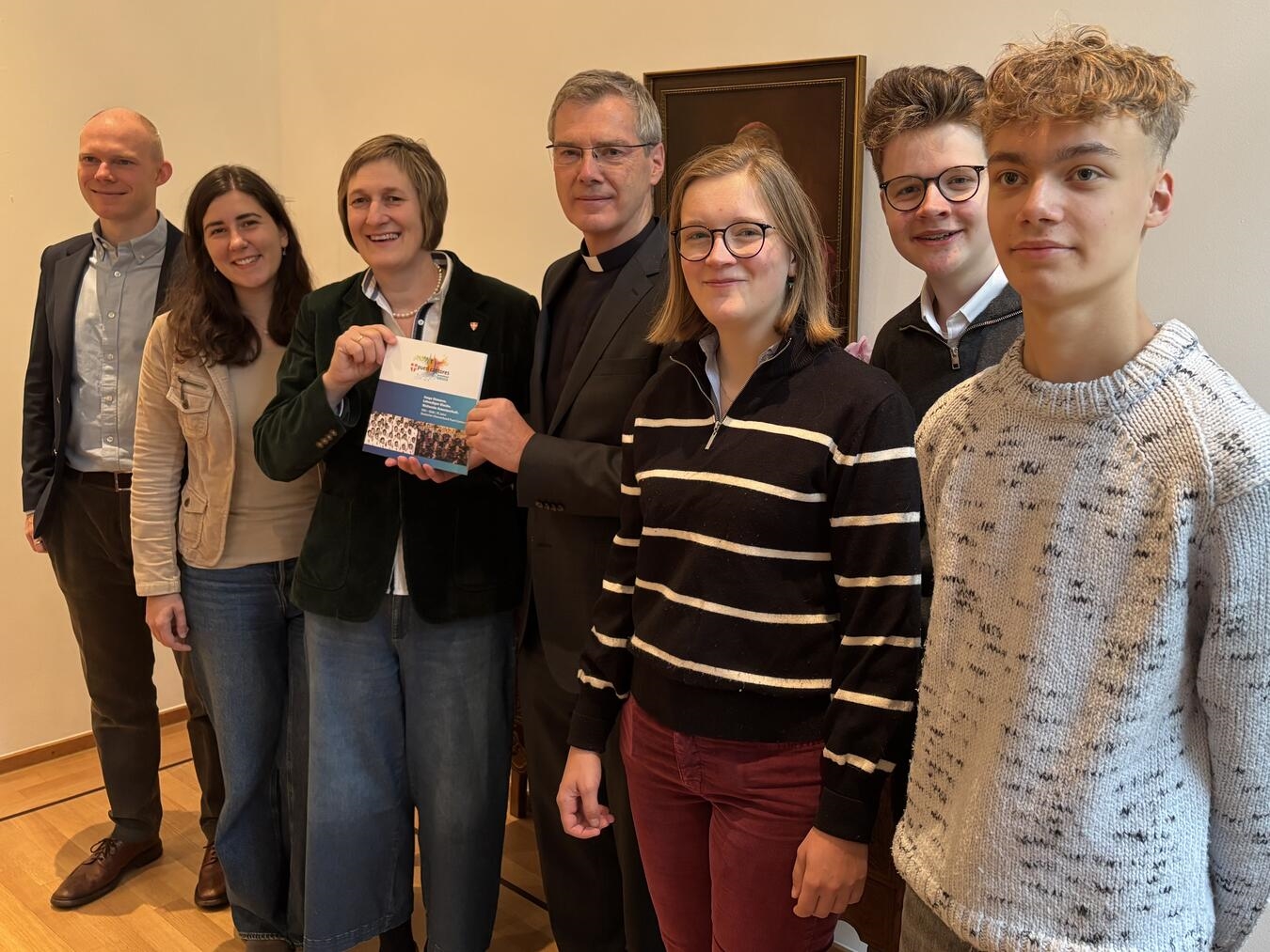 Übergabe der Festschrift mit sechs Personen im Gespräch, darunter Heiner Wilmer; feierlicher Anlass, Gruppenfoto.