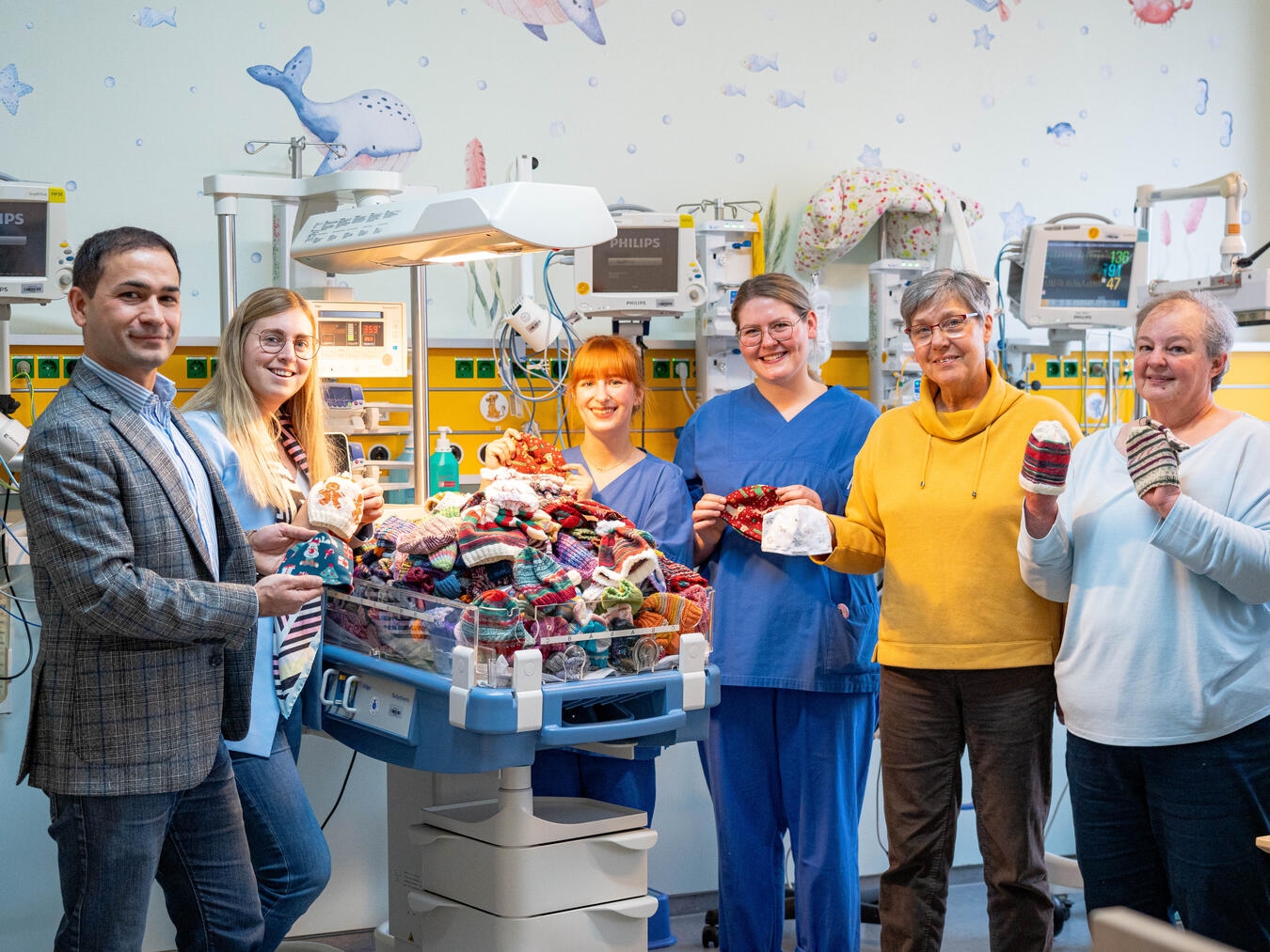 Bei der Übergabe der selbstgestrickten Kleidungsstücke (v.l.): Sadik Tastan, Eva Ullmann, Sophie Schulze, Shirley Arlt, Heike Grote, Ulrike Heetlage. Foto: KKLE/Weitwinkel Medien