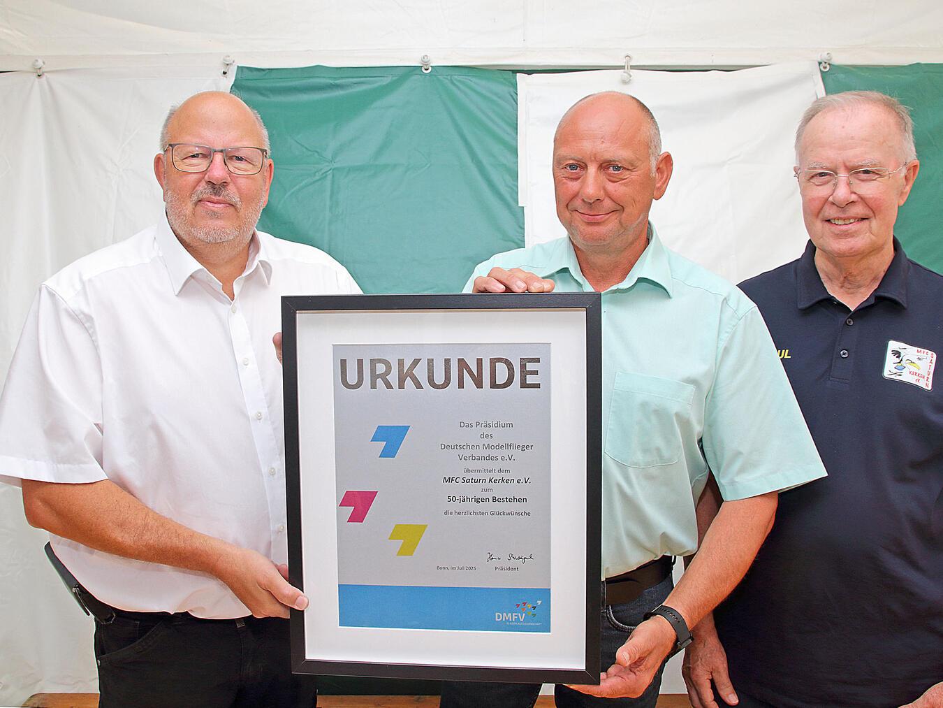 Beim Festakt zum Jubiläum überreichte Uwe Naujoks, Regionalbeauftragter des Deutschen Modellfliegerverbandes, die Urkunde an den 1. Vorsitzenden des MFC, Thomas Mesenhol, und den Schriftführer und 2. Vorsitzenden Paul Thiel. Der MFC Saturn Kerken hat derzeit 75 Mitglieder, davon fünf passive Mitglieder.NN-Fotos: Theo Leie