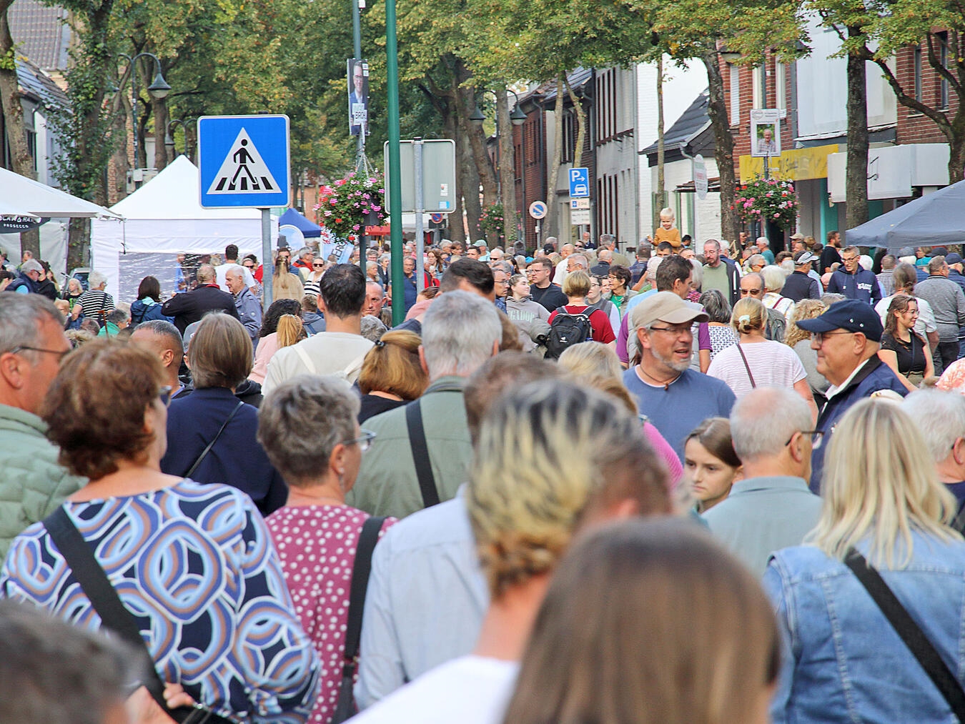 "Herbstmarkt mit Menschenmenge und bunten Ständen, festliche Atmosphäre"