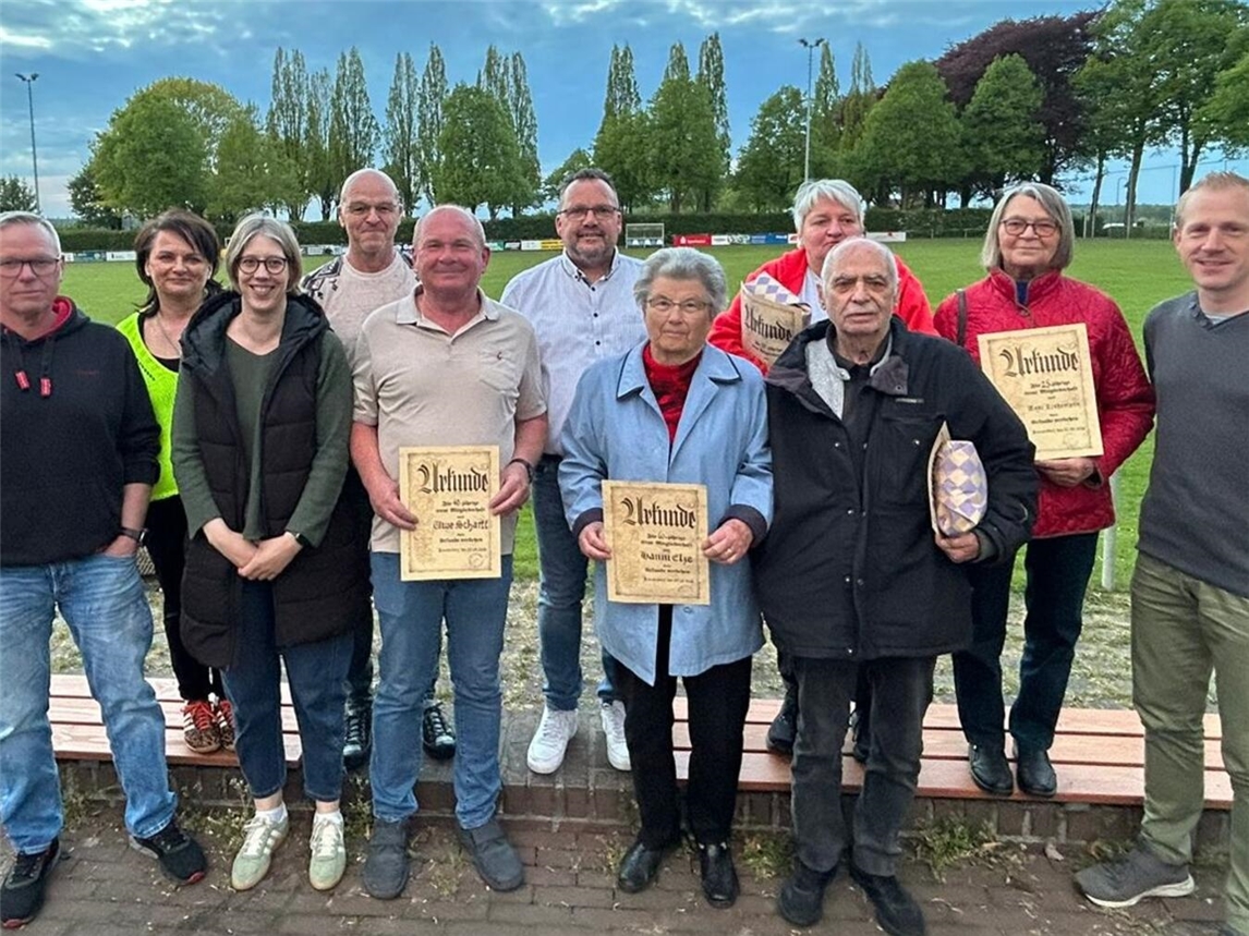 "Gruppenfoto bei SSV Louisendorf mit Ehrungen, Vereinsmitglieder in festlicher Kleidung, Feierlichkeit"