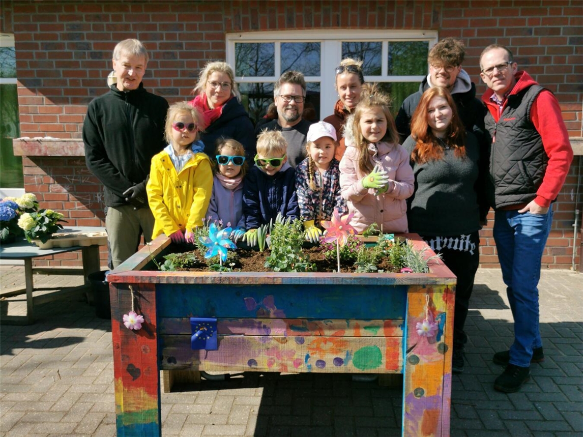 "Gruppenfoto vor bepflanztem Hochbeet, Beteiligte aus BBZ und Agrobusiness Niederrhein, Jugendliche und Betreuer, Gartenprojekt"