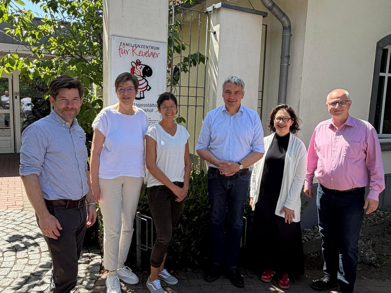 Gruppenfoto von Caritas- und Ministeriumsvertretern bei einer Kitabesichtigung.