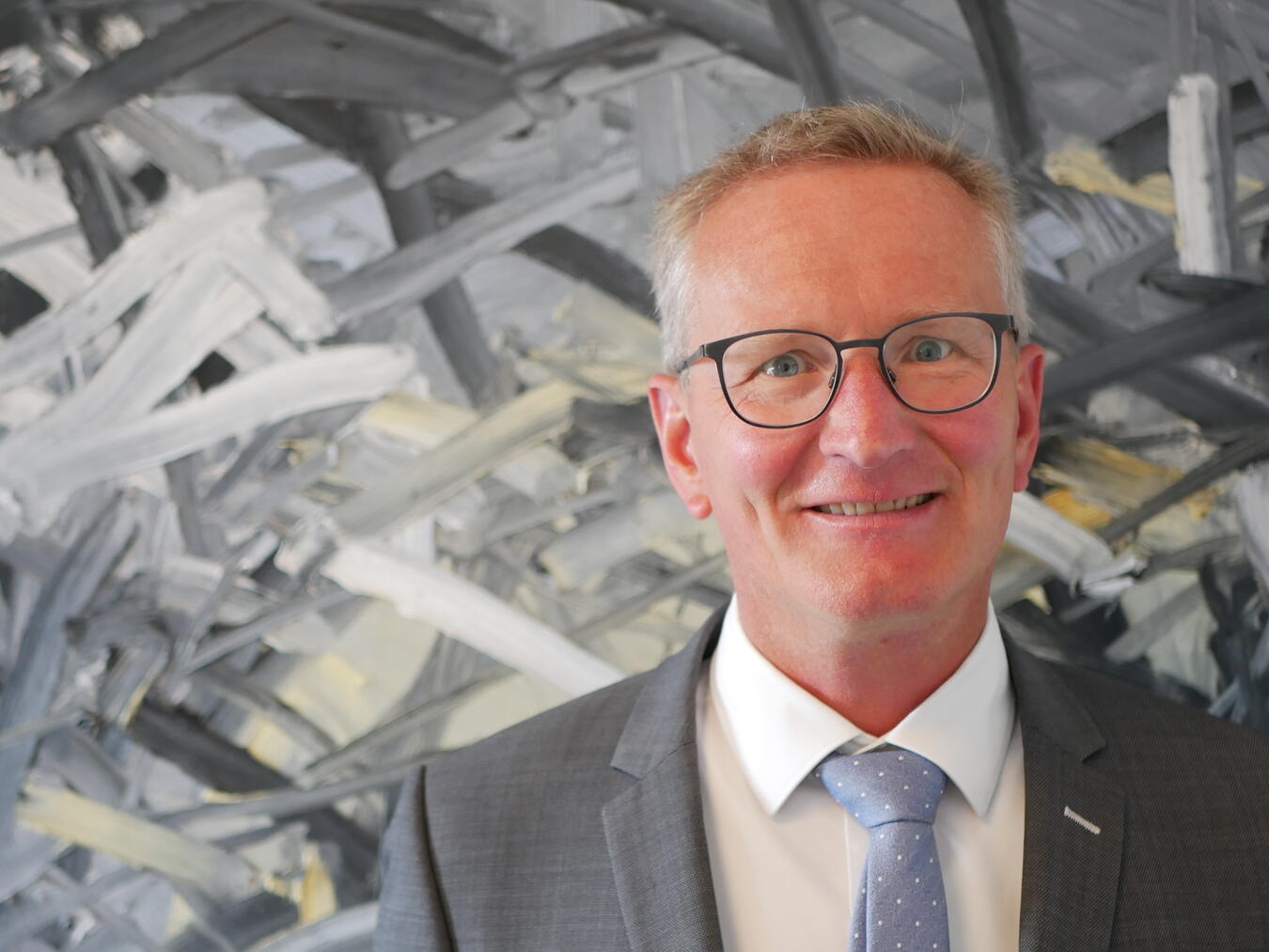 "Porträt von Bernhard Schröer, lächelnder Mann mit Brille im Anzug, Business-Experte, Führungskraft, professionelles Profilbild"