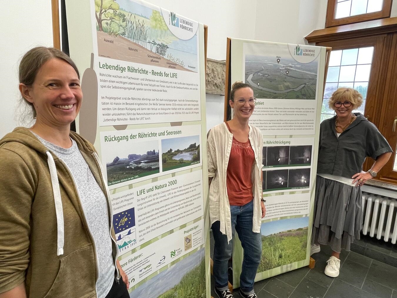 Ausstellung im Rathaus Kalkar: „Lebendige Röhrichte“ Bettina Blöß und Johanna Dohle vom Naturschutzzentrum im Kreis Kleve und Kalkars Bürgermeisterin Britta Schulz (v.l.) präsentieren die Ausstellung. Foto: Stadt Kalkar