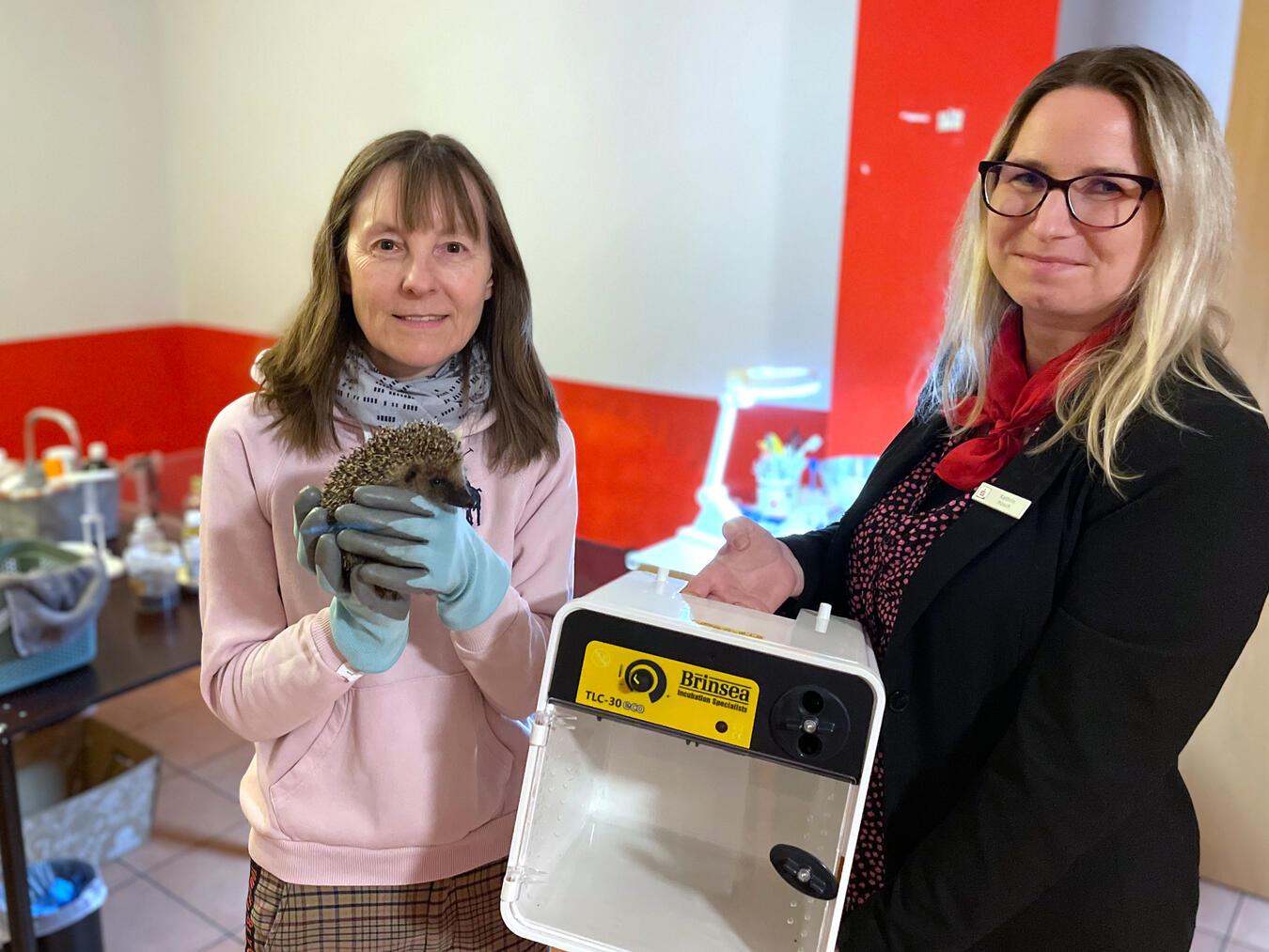 Bianca Ritter-Kowalczik (l.) mit einem von 14 Igeln, die sie derzeit betreut. Die Vereinsvorsitzende der ‚Igelfreunde Alpen‘ freut sich über eine 700-Euro-Spende der Sparkasse am Niederrein. Damit konnte unter anderem ein neuer Inkubator gekauft werden. Geschäftsstellenleiterin Kathrin Hüsch (r.) durfte die Igel-Station besichtigen.Foto: Sparkasse