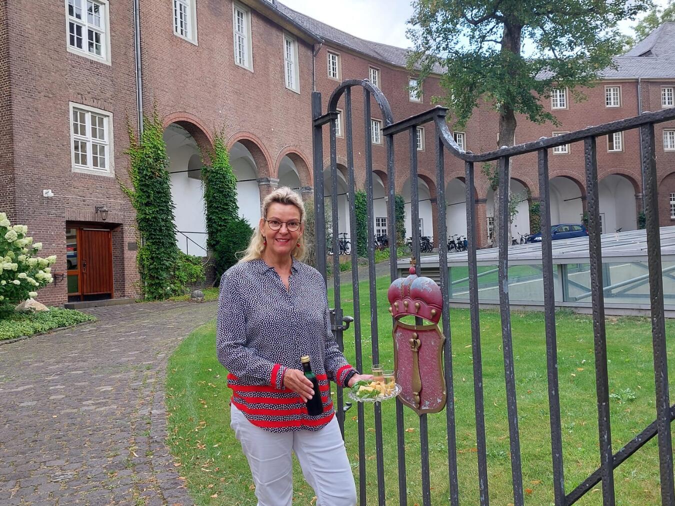 Birgit van den Boom mit Käse und Wein vor der Schwanenburg. Foto: WTM
