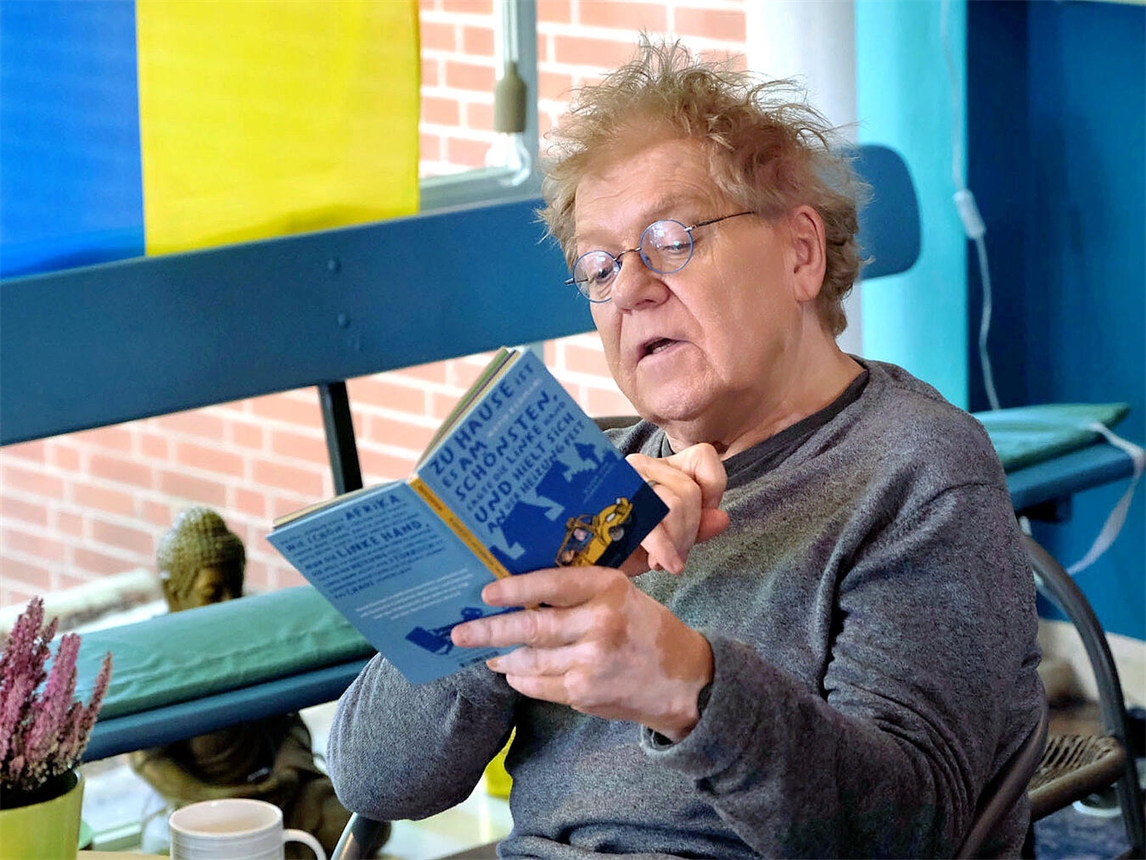 "Theaterplakat mit Titel 'Zu Hause ist es am schönsten', linke Hand greift Heizung, Premiere am 4. Dezember"