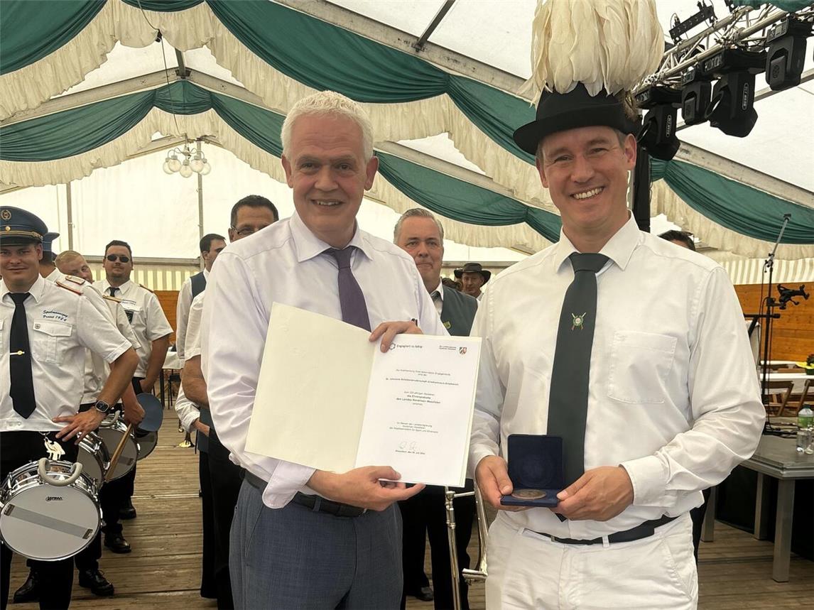 Brudermeister Bernd Enders und Dr. Günther Bergmann bei der Übergabe von Urkunde und Ehrenplakette im Schützenzelt. Foto: privat