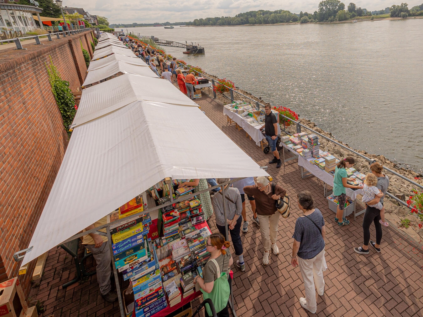 "Bücherstöbern am Reeser Büchermarkt mit Rheinblick, 16. August, Rheinpromenade. Foto: Axel Breuer"