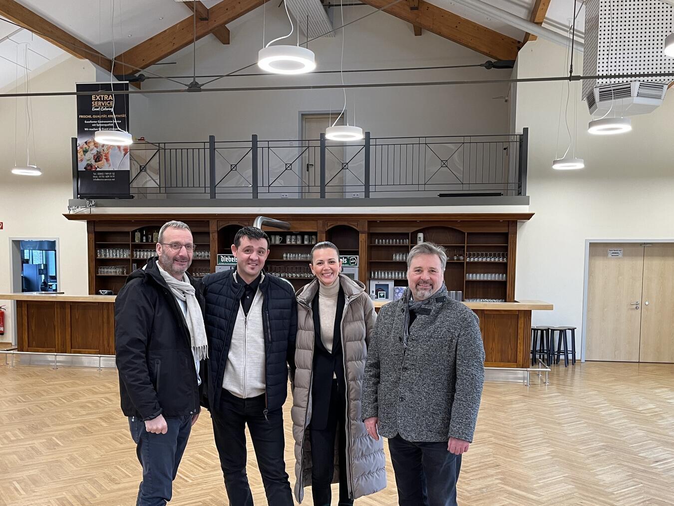 Bürgermeister Clemens Brüx (r.), Olga und Andrej Dause, Pächter des Bürgersaals (m.), und Frithjof Gerstner, Westenergie-Kommunalmanager (l.) am Tag der Inbetriebnahme der neuen LED-Leuchten, die im Bürgersaal Issum und den dazugehörigen Nebenräumen installiert wurden.Foto: Westenergie AG