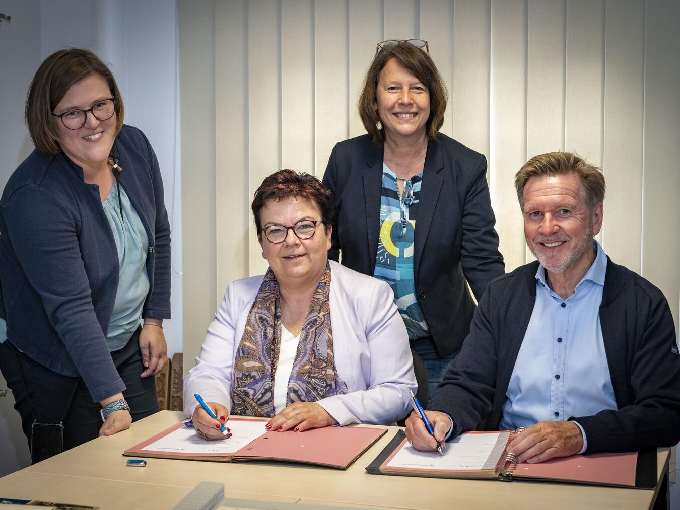 Bürgermeister Dirk Möcking und Schulleiterin Dr. Claudia Eberle unterschreiben die Bildungspartnerschaft zwischen dem Gemeindearchiv Kerken und der Robert-Jungk-Gesamtschule (RJGE) Krefeld-Kerken. Die RJGE-Abteilungsleiterin für Kerken, Sinje Michel (l.), und Archivarin Nicole Sillekens freuen sich auf die Zusammenarbeit. Foto: Gemeinde Kerken